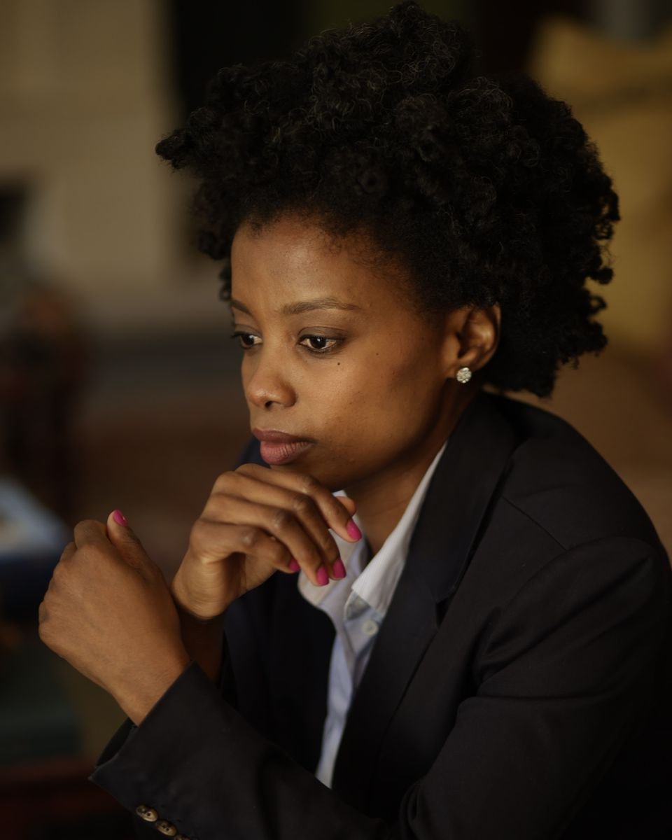 Maud Nale in a navy suit, chin resting on her hand, deep in thought